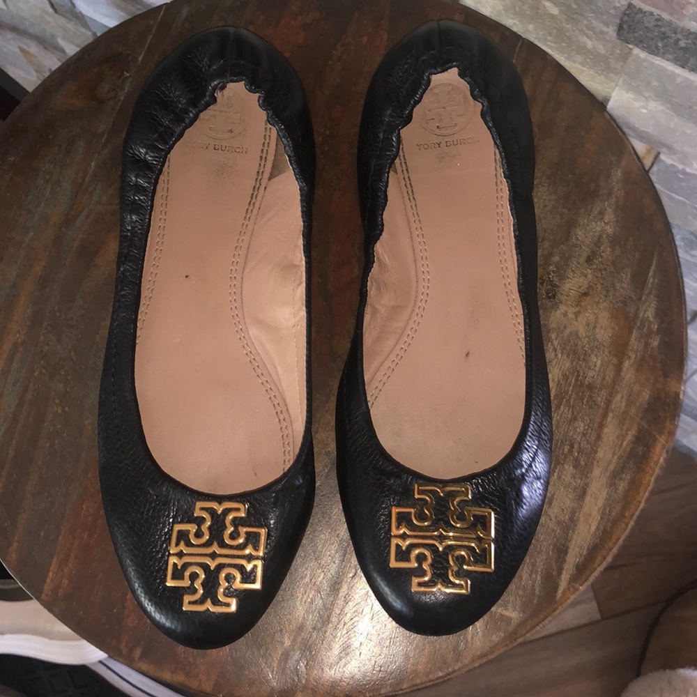 Tory Burch flats with gold emblem.